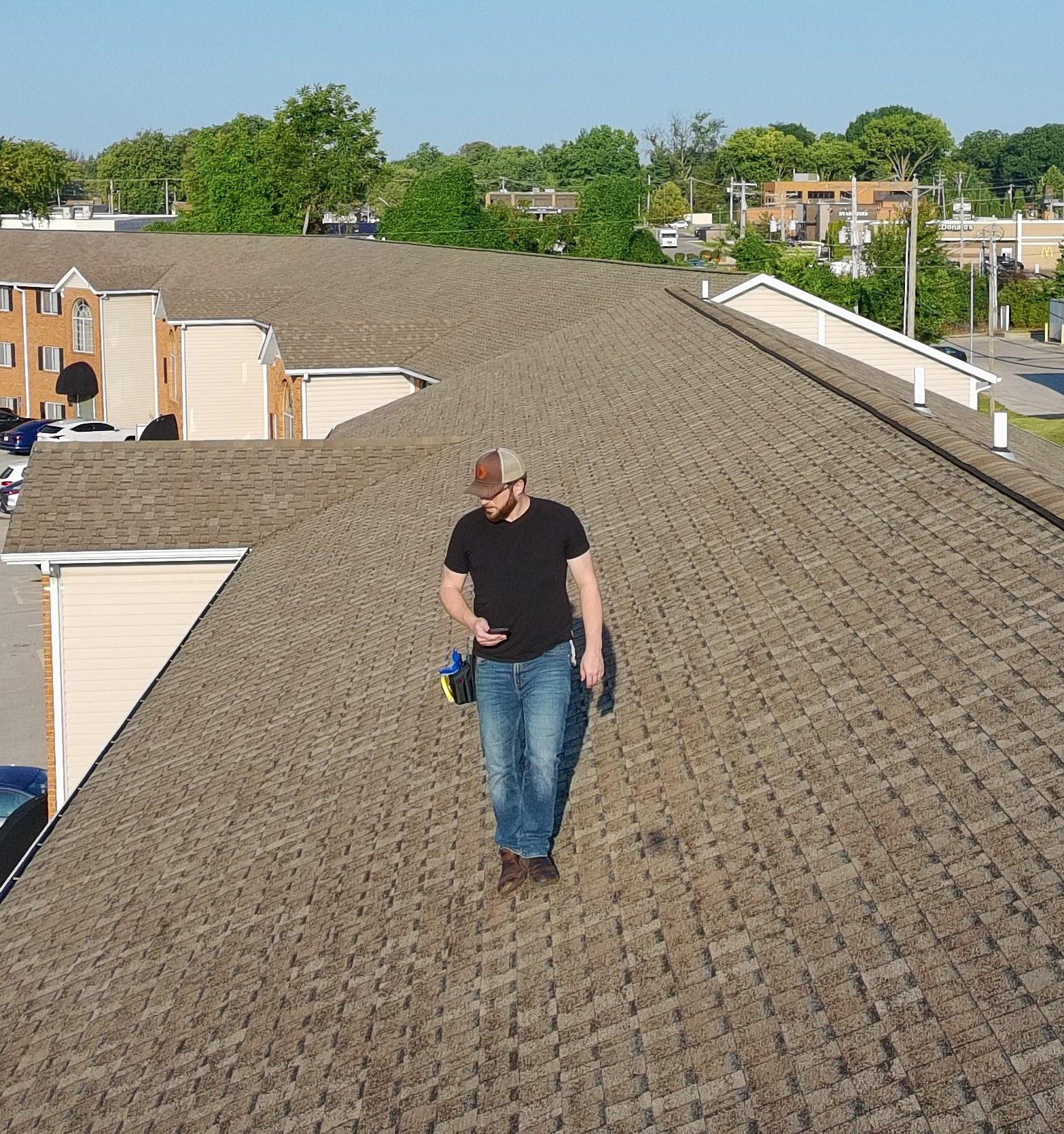 Vanguard adjuster walking a shingle roof during a storm damage inspection